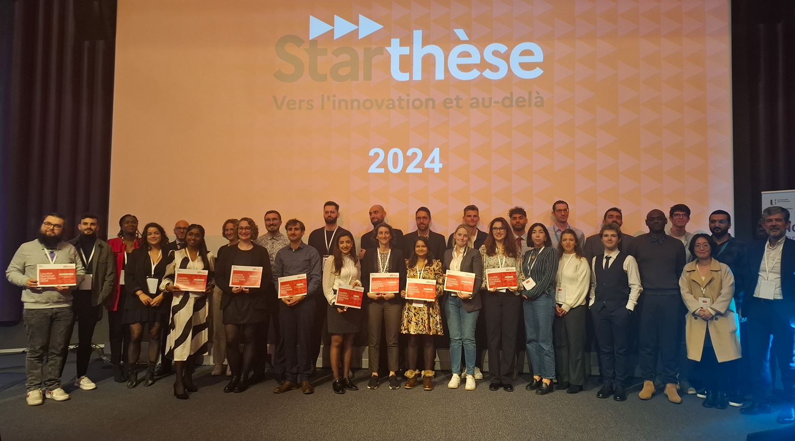 21 lauréats Starthèse sur la scène du centre de conférence de Météofrance, à Toulouse